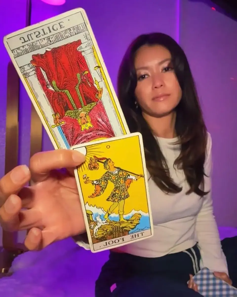 Eli Marie holding tarot cards during a live reading