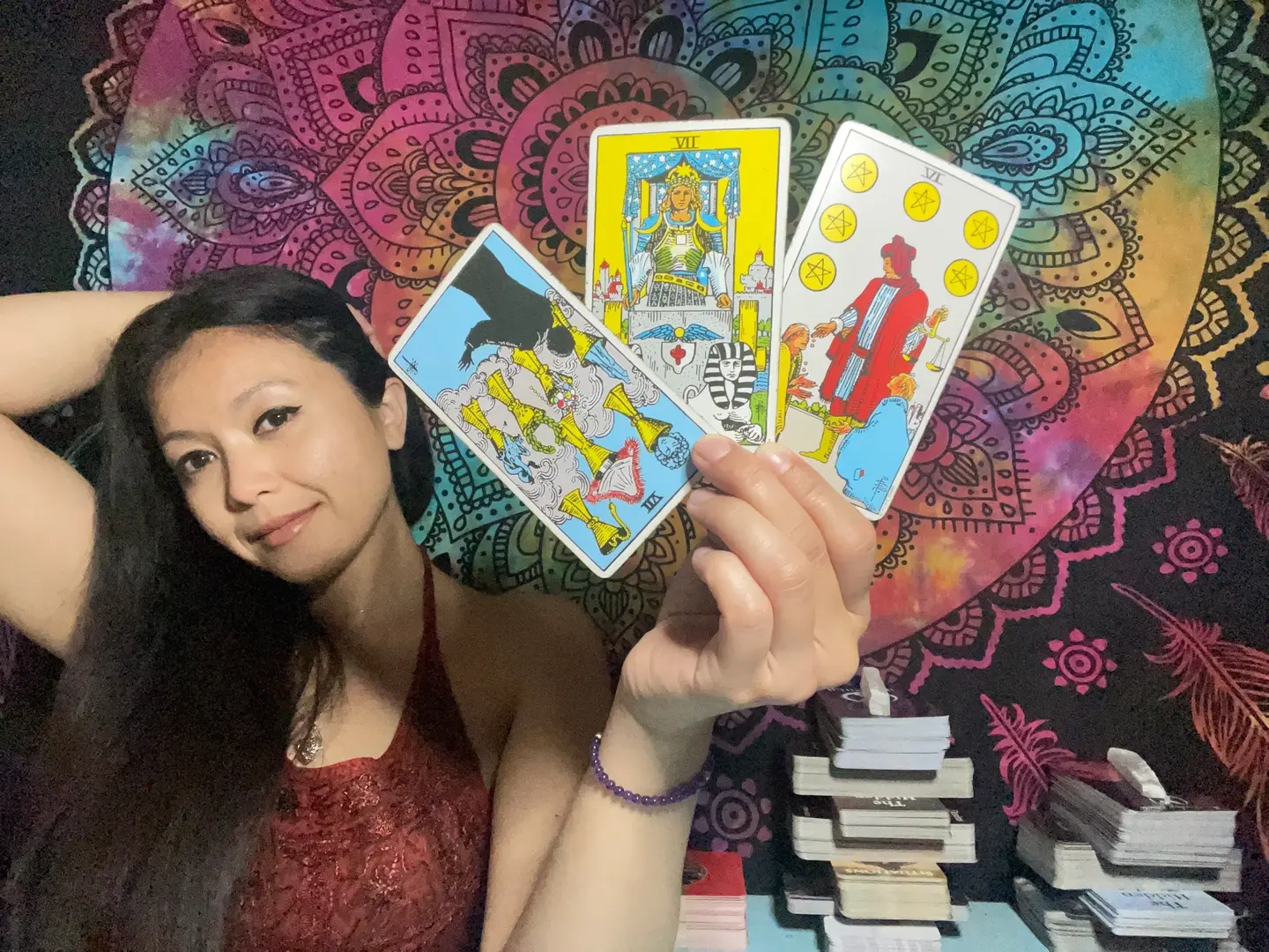 Eli Marie holding three tarot cards for a reading
